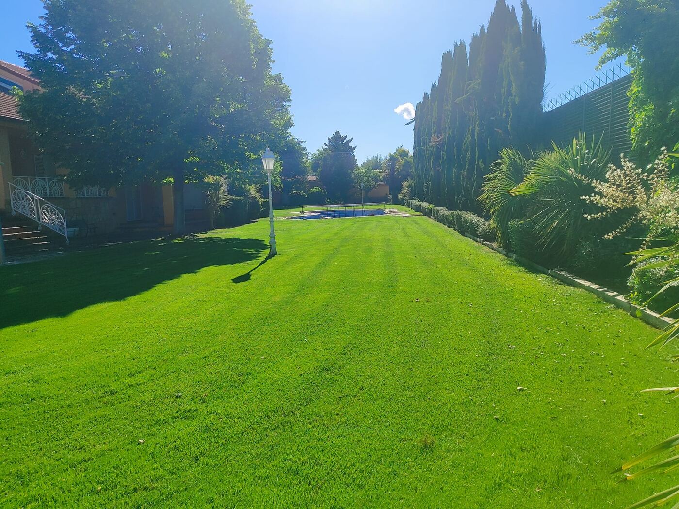 Jardín amplio con piscina y césped cuidado
